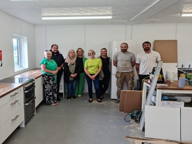 MCP and Ideal for All members standing in the half-constructed kitchen